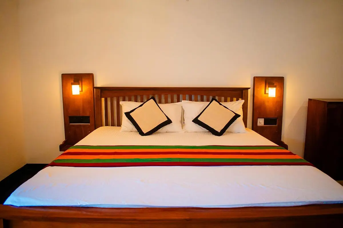 King-size bed with a striped throw and twin reading lamps
