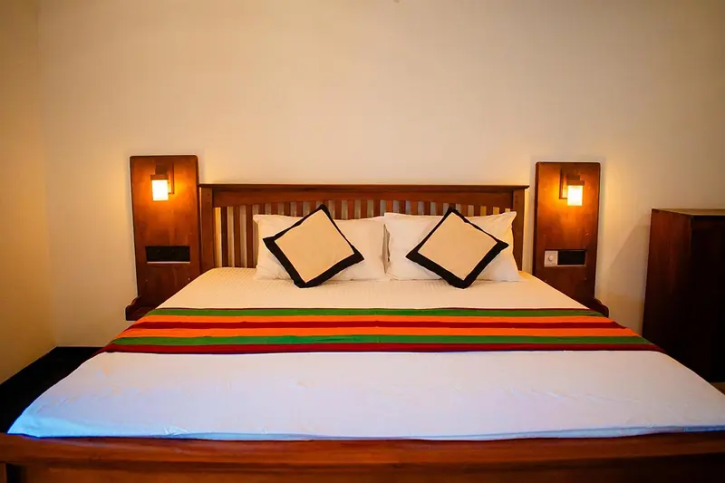 King-size bed with a striped throw and twin reading lamps