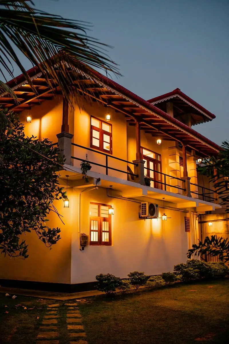 The villa's tiled roofs and lit windows at dusk