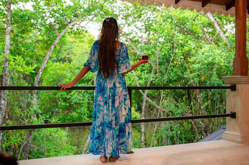 A guest looking out over the mangroves from the veranda rail