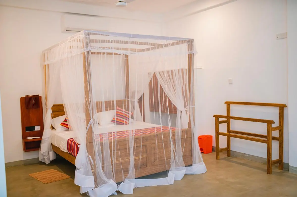 Four-poster king bed draped with a white mosquito net