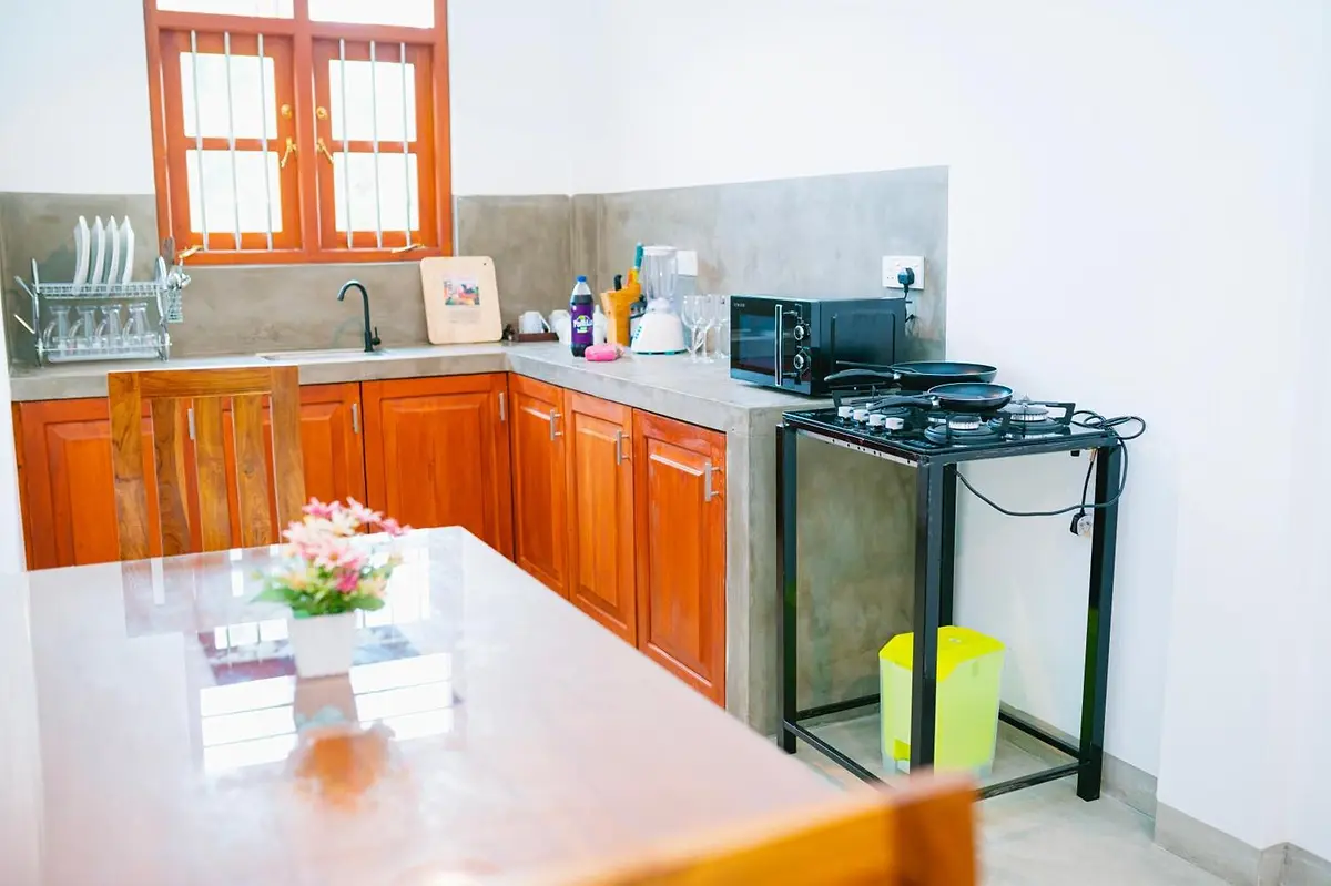 Kitchen and dining table with gas hob, microwave and kettle